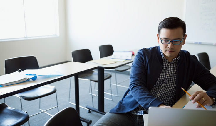 man with pencil and laptop